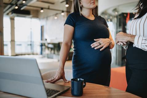 Pregnant woman talking to coworker - Wrongful Termination